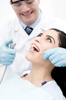 عکس دکتر دندانپزشک در حال جراحی دندان