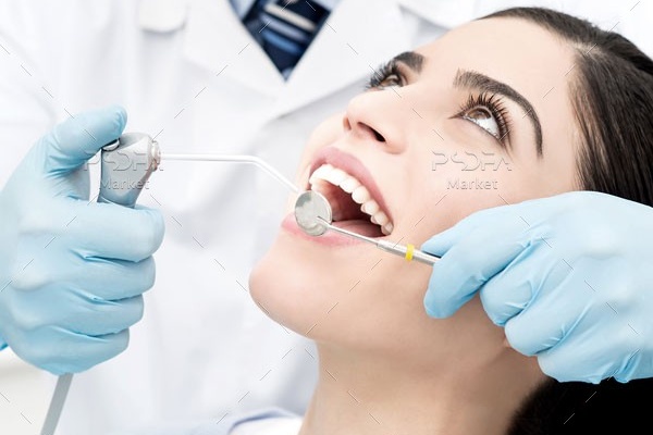 عکس دکتر دندانپزشک در حال جراحی دندان