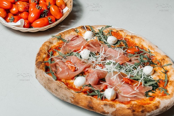 عکس با کیفیت پیتزا ایتالیایی با ژامبون و سبد گوجه فرنگی