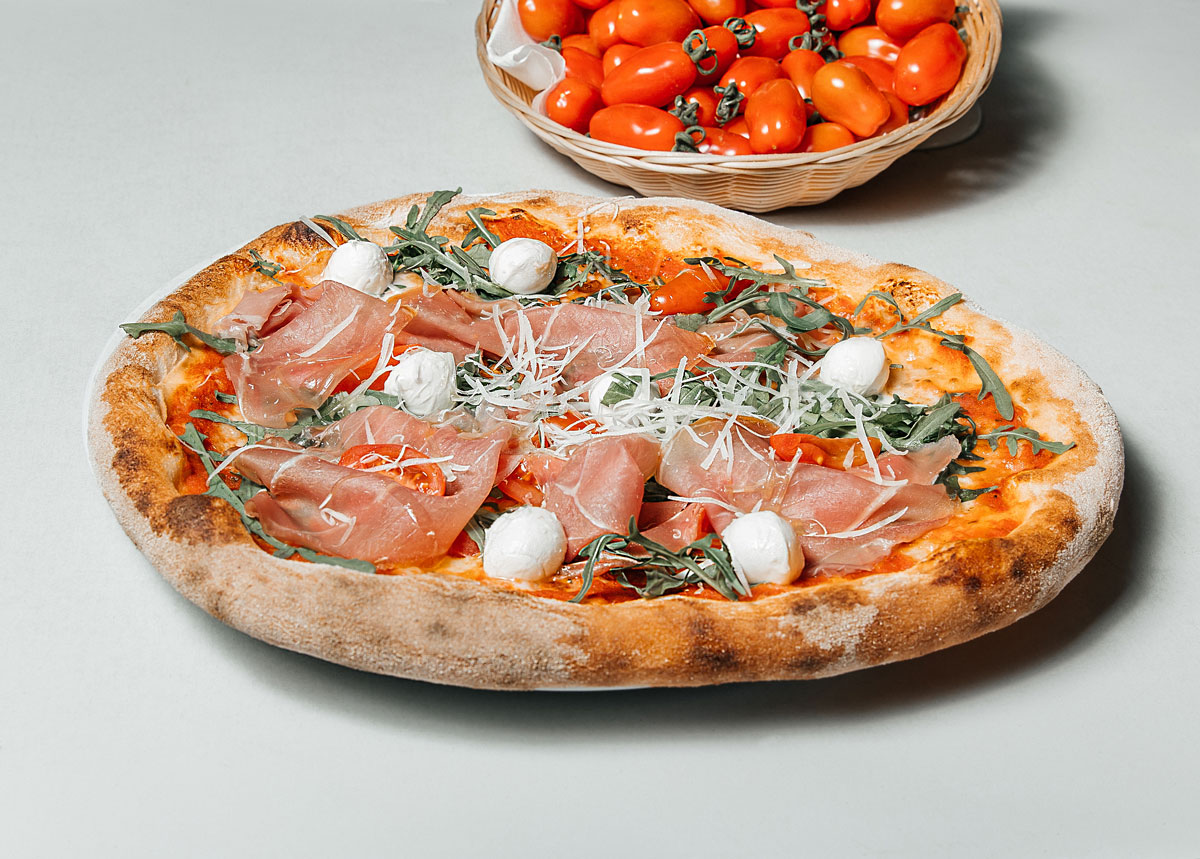 تصویر استوک پیتزا سنتی ایتالیایی با ژامبون و پنیر موزارلا