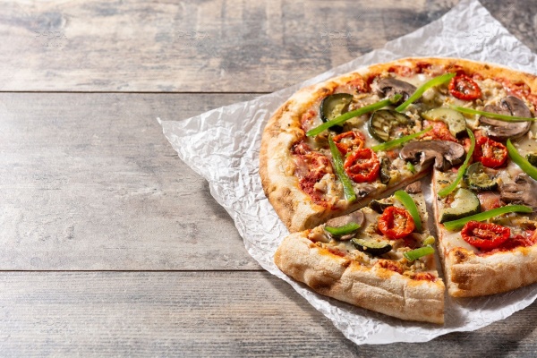 تصویر استوک پیتزا سبزیجات روی کاغذ و میز چوبی