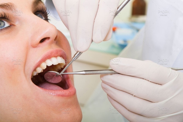 عکس استوک دندانپزشک در حال معاینه بیمار