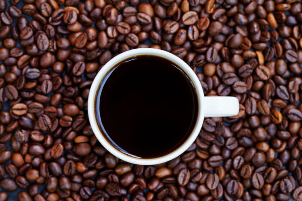 فنجان قهوه روی دانه‌های قهوه